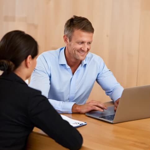 En revisor der sidder og arbejder med en kunde